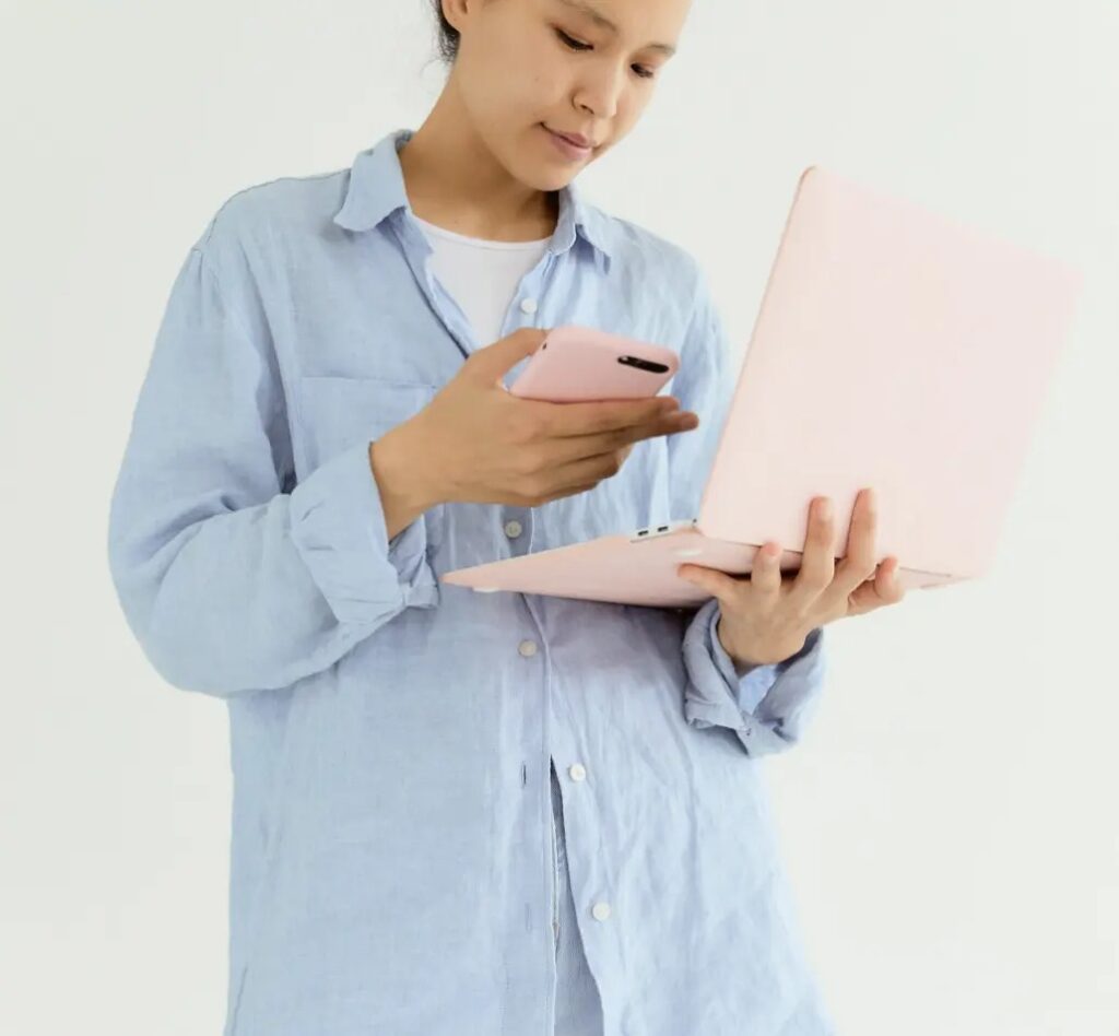 A USA citizen holding mobile and laptop on her hand.